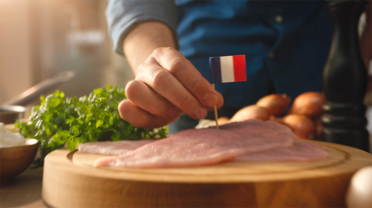 Homme qui plante un drapeau français dans une viande.