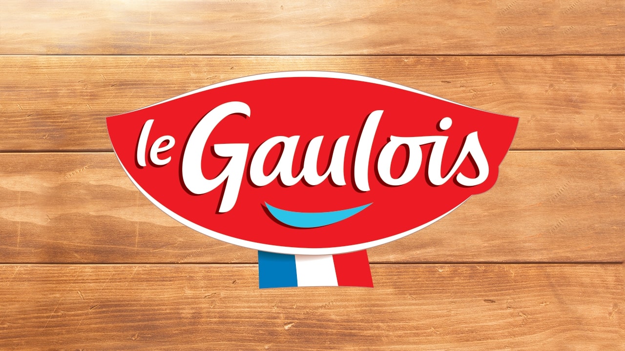 Houten eettafel met het logo van Le Gaulois op de achtergrond