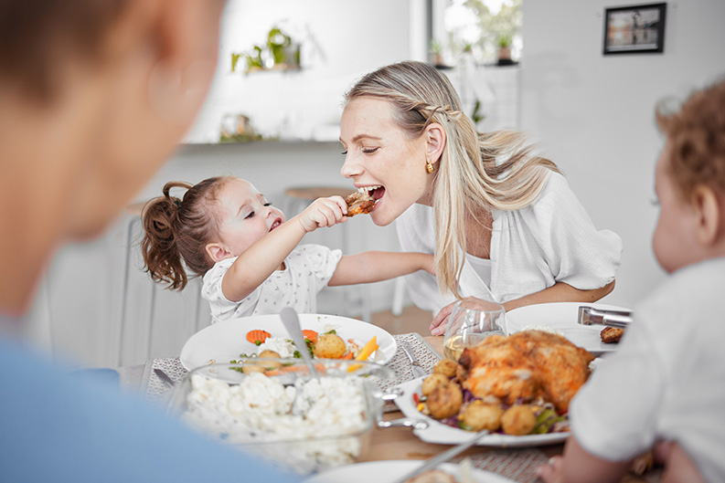 Enfant donne à manger du poulet à sa maman avec les mains