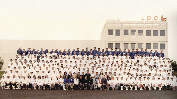 Photo de classe de tous les salariés devant le bâtiment LDC pour inaugurer la création de Le Gaulois en 1984