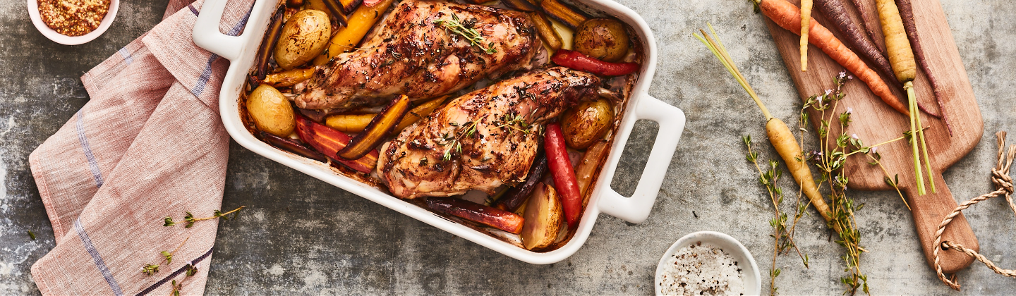 Cuisses de lapin recouverte de moutarde et de thym, accompagnées de pommes de terre et de carottes rôtis au four