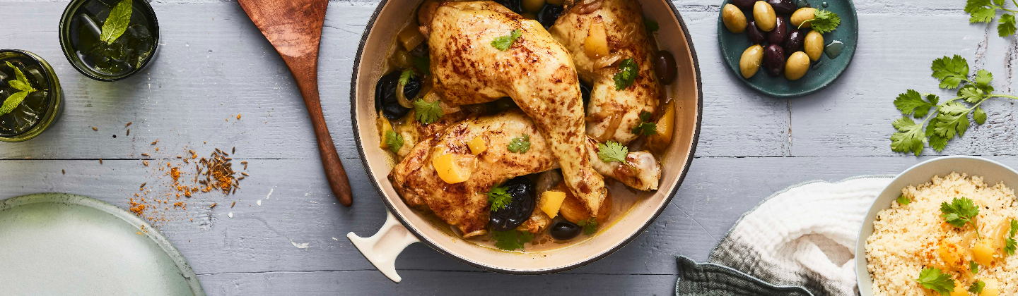 Cuisses de poulet cuitent en cocotte avec des olives, abricots et pruneaux secs, accompagnées d'une semoule