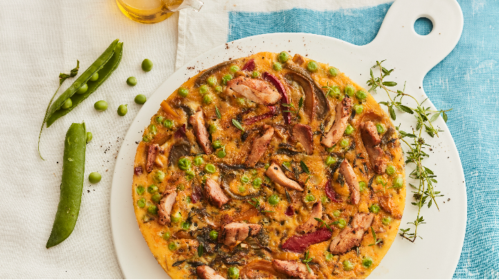 Visuel recette d'une frittata aux émincés de poulet rôti saveurs kebab, agrémenté de poivrons, oignons et petits pois