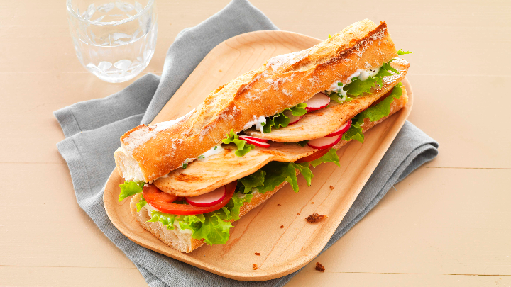 Visuel recette d'un sandwich aux escalopes de poulet garni de salade, tomates et radis