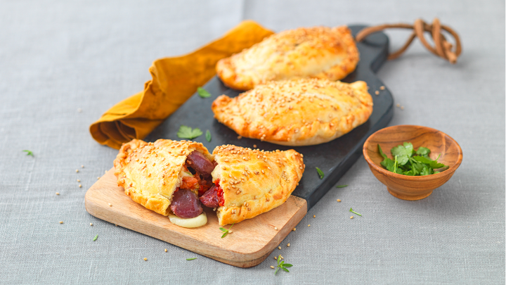 Visuel recette d'empanadas aux gésiers de volaille confits, tomates confites et tommes de chèvre sur une planche apéro