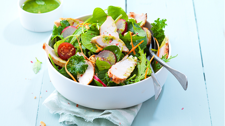 Visuel recette d'une salade de poulet sauce pesto, agrémentée de carotte râpé, tomates et radis