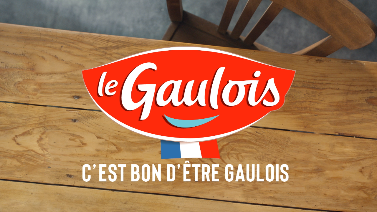 Table à manger en bois en arrière plan avec le logo Le Gaulois et le slogan "c'est bon d'être Gaulois" en premier plan