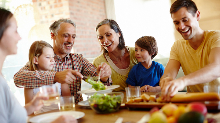 Famille souriante autour d'un bon repas à table